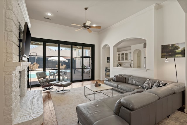 living area with recessed lighting, visible vents, ornamental molding, a ceiling fan, and wood finished floors