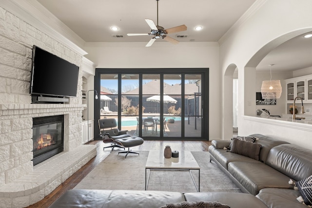 living room featuring ornamental molding, a brick fireplace, and visible vents