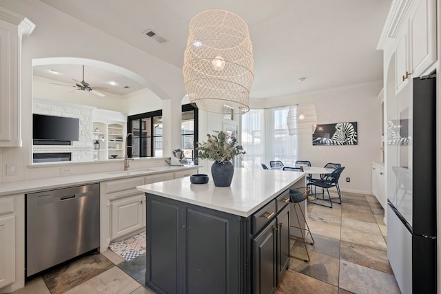 kitchen with visible vents, white cabinetry, light countertops, ornamental molding, and appliances with stainless steel finishes