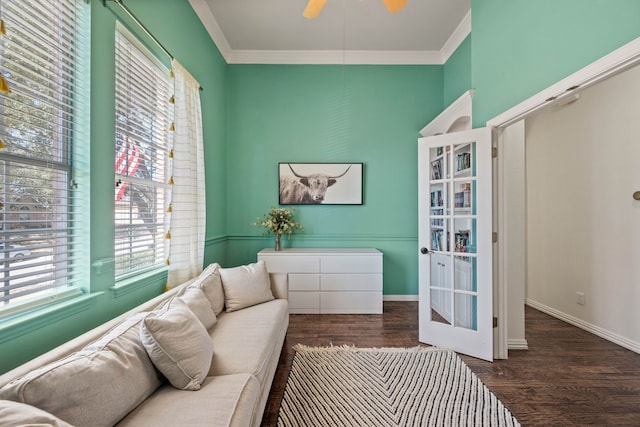 living area featuring crown molding, baseboards, and wood finished floors