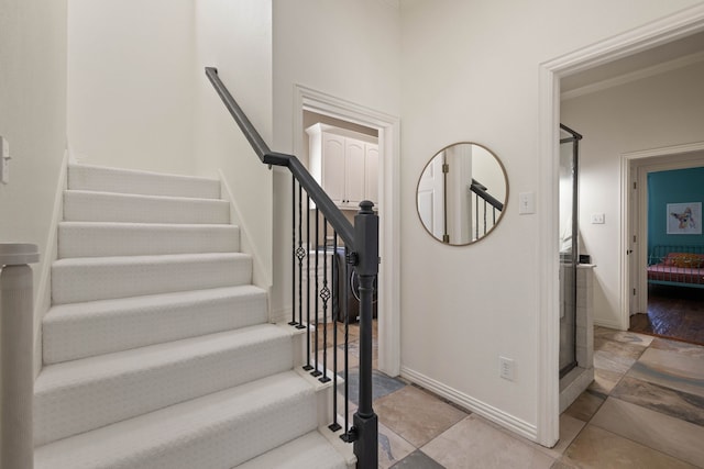 stairs featuring ornamental molding and baseboards