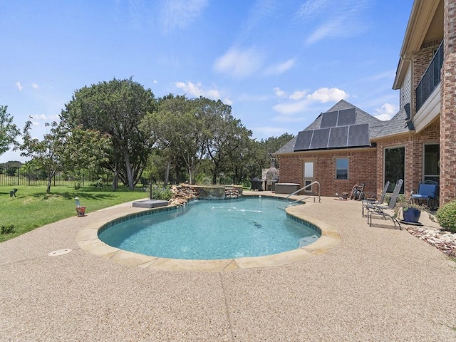 view of pool featuring a pool with connected hot tub, a lawn, and a patio