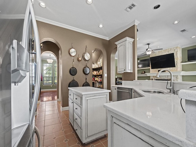 kitchen featuring crown molding, arched walkways, stainless steel appliances, and a sink