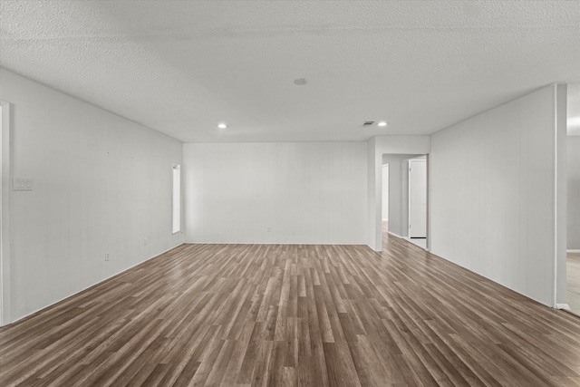 unfurnished room featuring a textured ceiling and wood finished floors