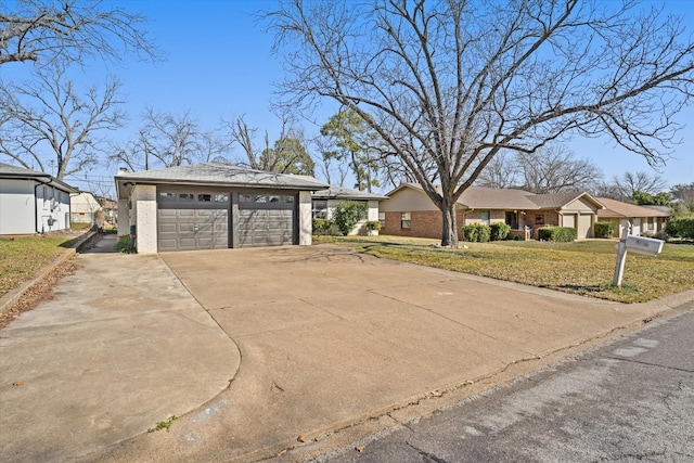 exterior space featuring driveway, brick siding, an outdoor structure, and a front yard