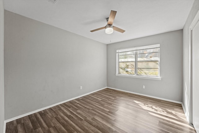 spare room featuring a ceiling fan, baseboards, and wood finished floors