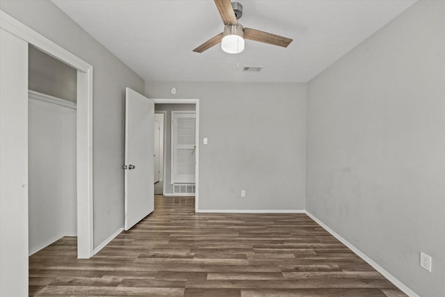 unfurnished bedroom featuring wood finished floors, a ceiling fan, visible vents, baseboards, and a closet