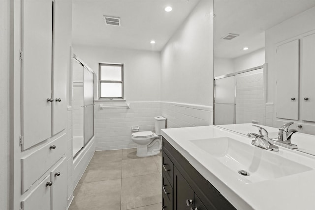 full bath with toilet, a wainscoted wall, tile patterned flooring, and visible vents