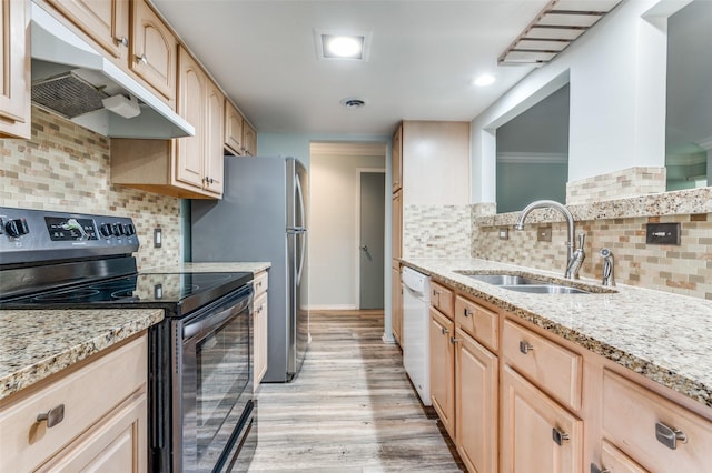 kitchen with light stone counters, light brown cabinetry, appliances with stainless steel finishes, a sink, and under cabinet range hood