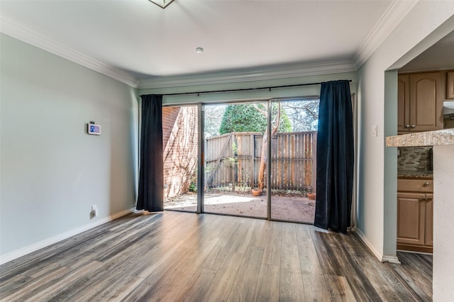 empty room with baseboards, dark wood-type flooring, and crown molding