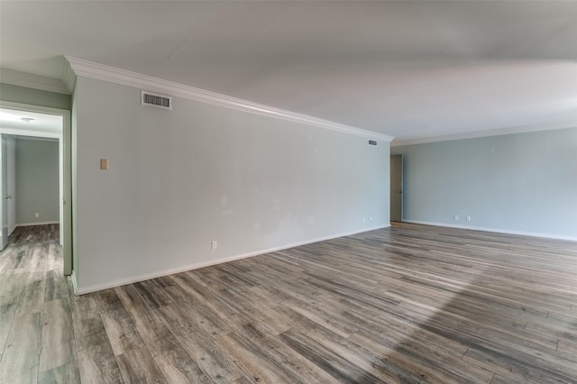 empty room featuring visible vents, crown molding, and wood finished floors