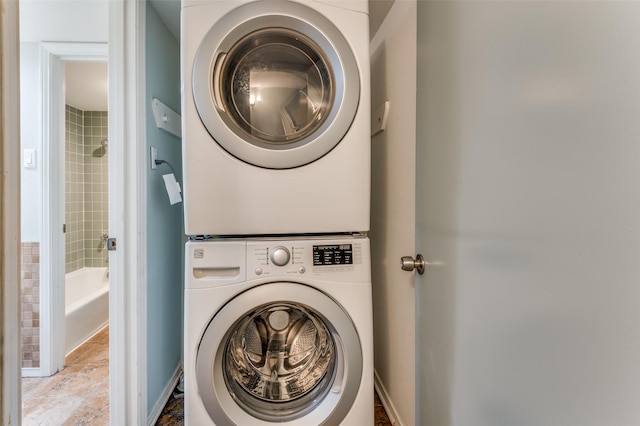 clothes washing area with stacked washer and dryer and laundry area