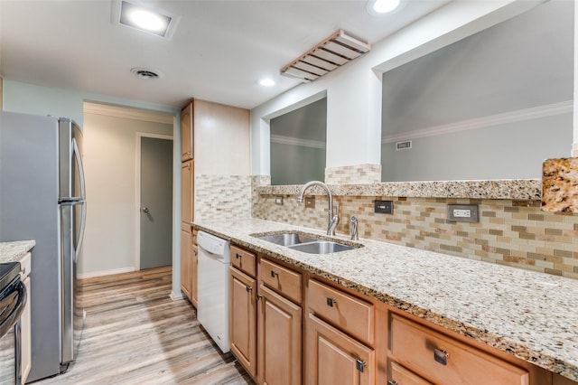 kitchen featuring visible vents, light stone counters, ornamental molding, white dishwasher, and a sink