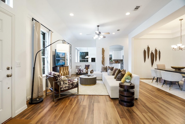 living area featuring visible vents, arched walkways, wood finished floors, and recessed lighting