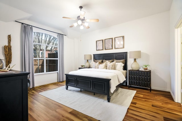 bedroom with ceiling fan, wood finished floors, and baseboards