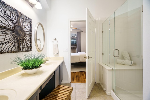 ensuite bathroom featuring a stall shower, tile patterned flooring, a sink, and ensuite bath