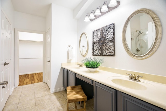 full bathroom featuring double vanity, a sink, a spacious closet, and tile patterned floors