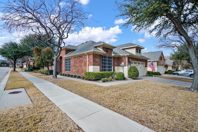 view of front facade with concrete driveway, brick siding, roof with shingles, and a front yard