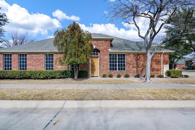 view of front of home featuring a shingled roof and brick siding