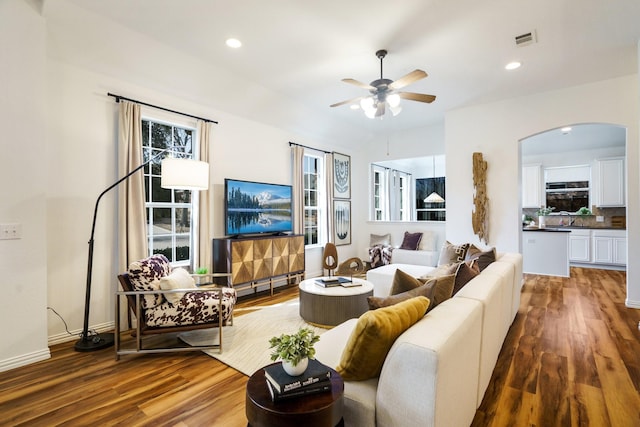 living room featuring visible vents, arched walkways, wood finished floors, and recessed lighting