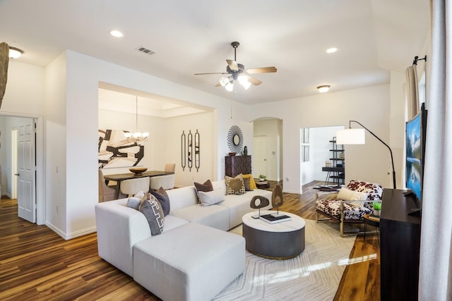 living room featuring recessed lighting, visible vents, arched walkways, wood finished floors, and ceiling fan with notable chandelier