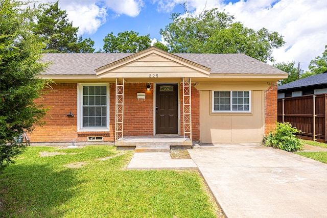 bungalow with roof with shingles, brick siding, a front lawn, and fence