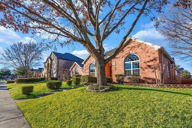 view of front of property featuring a front yard and brick siding