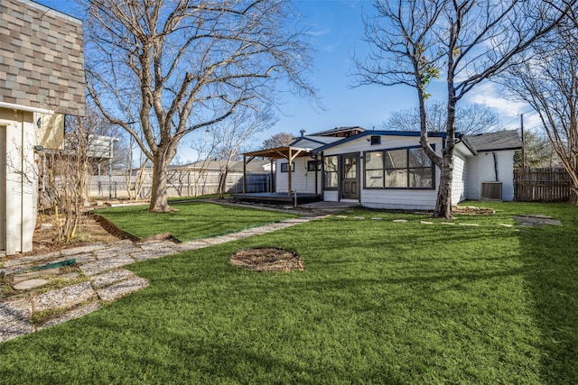 view of yard featuring cooling unit, a fenced backyard, and a sunroom