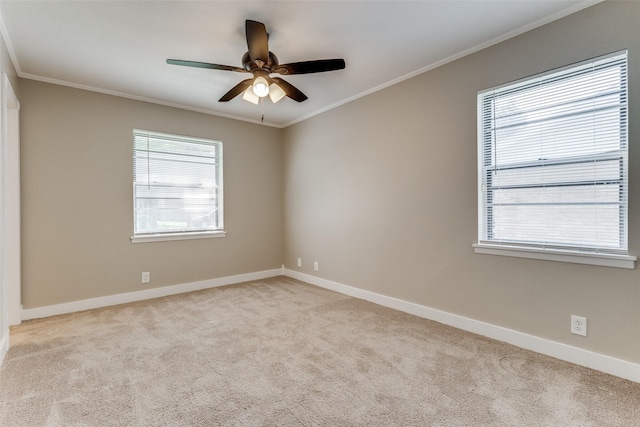 empty room with carpet flooring, crown molding, baseboards, and ceiling fan