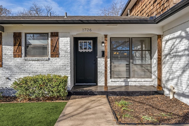 doorway to property with brick siding