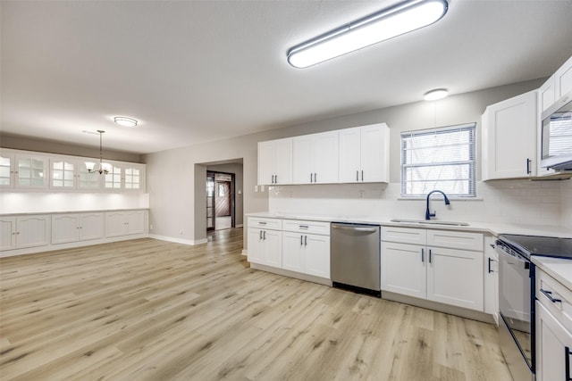 kitchen with tasteful backsplash, stainless steel appliances, light wood-type flooring, white cabinetry, and a sink