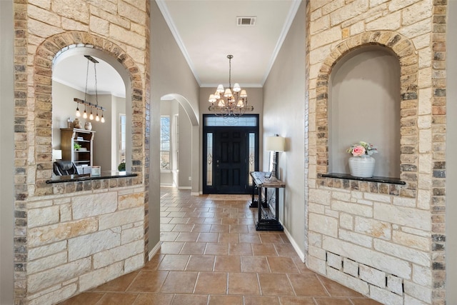 entryway featuring a chandelier, visible vents, crown molding, and baseboards