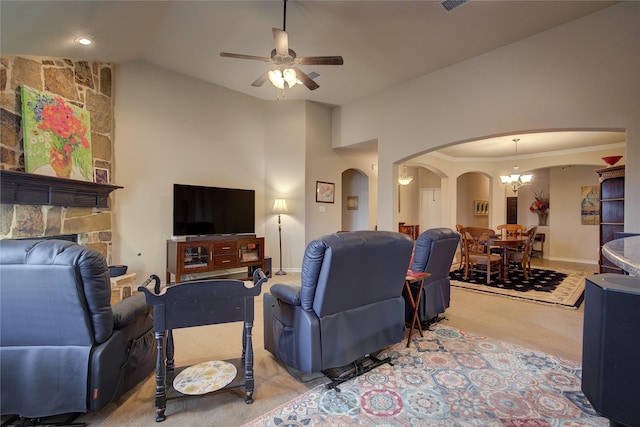 living room featuring arched walkways, ornamental molding, light carpet, vaulted ceiling, and ceiling fan with notable chandelier