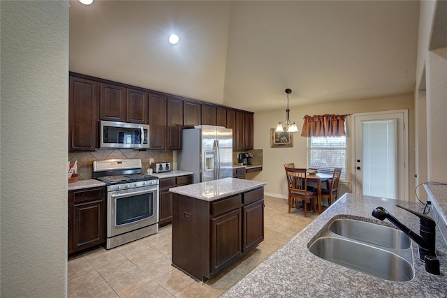 kitchen featuring decorative light fixtures, decorative backsplash, appliances with stainless steel finishes, a sink, and dark brown cabinetry