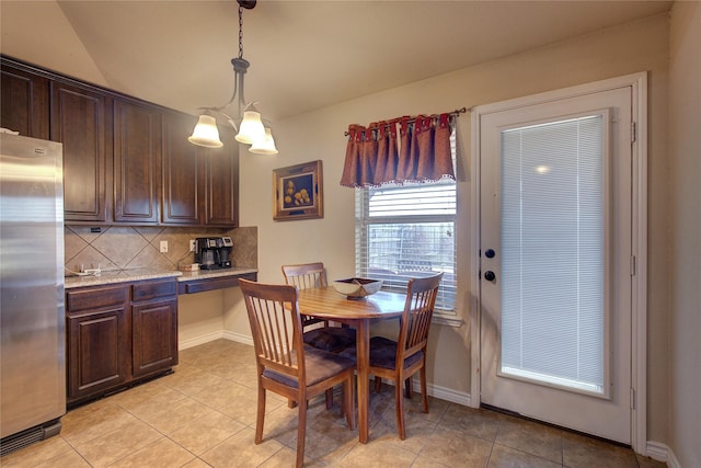 dining area with light tile patterned flooring, baseboards, and an inviting chandelier