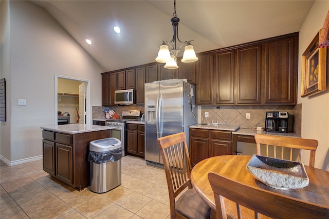 kitchen with a center island, light tile patterned floors, stainless steel appliances, dark brown cabinets, and a chandelier