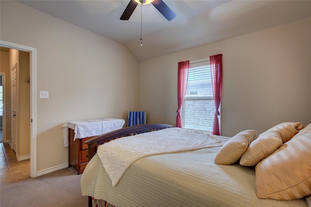 bedroom with light carpet, vaulted ceiling, a ceiling fan, and baseboards