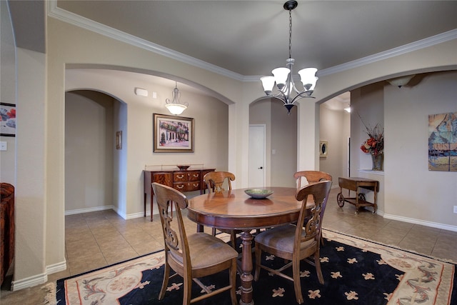 dining area with light tile patterned floors, arched walkways, a chandelier, baseboards, and ornamental molding