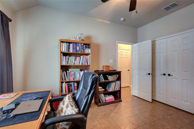 home office with light tile patterned floors, visible vents, vaulted ceiling, and a ceiling fan