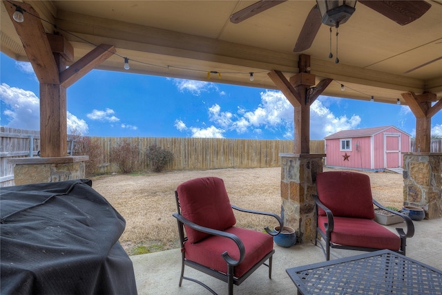 view of patio / terrace featuring a fenced backyard, an outdoor structure, a storage shed, and ceiling fan