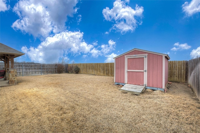 view of yard featuring a fenced backyard, a storage unit, and an outdoor structure