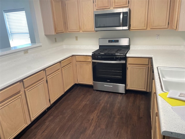 kitchen featuring appliances with stainless steel finishes, light countertops, dark wood-style flooring, and light brown cabinets