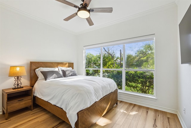 bedroom with a ceiling fan, light wood-style flooring, ornamental molding, and baseboards