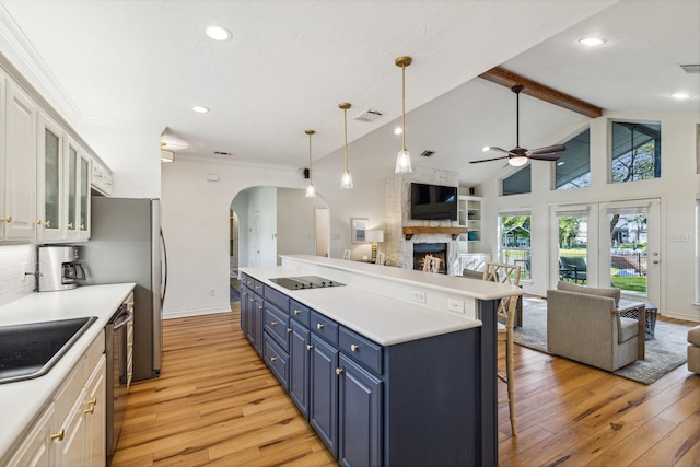 kitchen with light wood-style floors, dishwasher, open floor plan, blue cabinetry, and beam ceiling