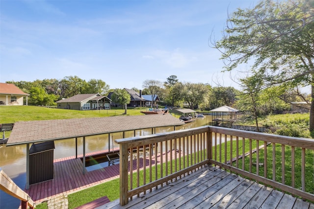 wooden deck with a boat dock, a water view, and a lawn