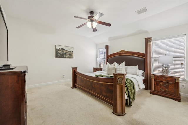 bedroom featuring lofted ceiling, multiple windows, visible vents, and light colored carpet