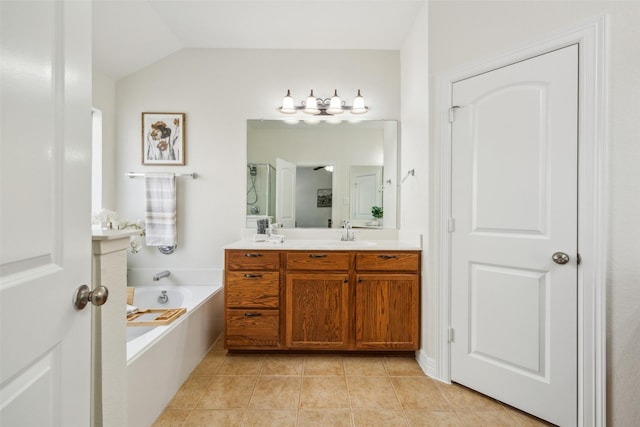 bathroom featuring a garden tub, double vanity, lofted ceiling, a sink, and tile patterned flooring