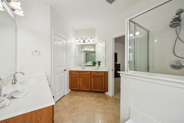 full bathroom with tile patterned flooring, a shower stall, two vanities, and a sink