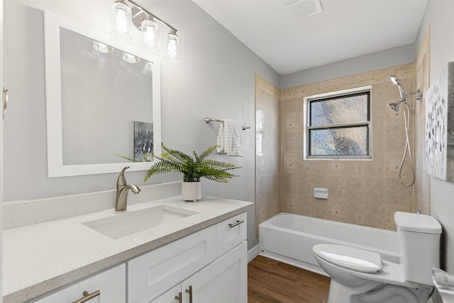 full bathroom featuring bathtub / shower combination, visible vents, toilet, vanity, and wood finished floors