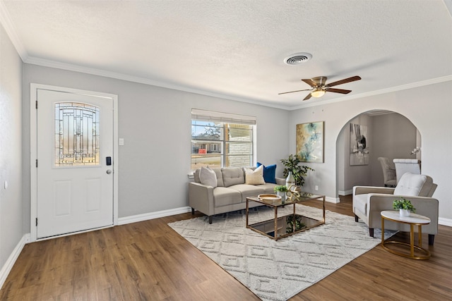 living room with visible vents, a ceiling fan, a textured ceiling, wood finished floors, and baseboards